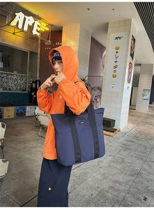 Navy blue canvas tote bag styled by a model in a trendy urban street setting