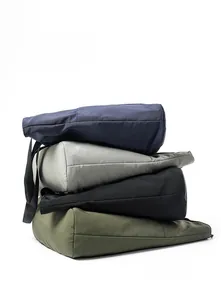 Multiple colors of large nylon tote bags stacked against a clean white background