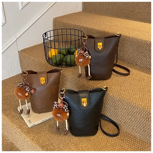 Detailed view of mini bucket bags with leather texture and cute plush doll charms