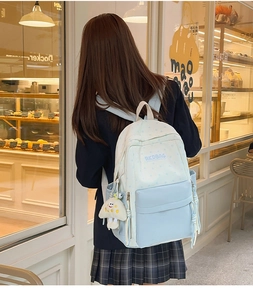 Detail of light blue and cream patchwork school bag with star prints and plush charm