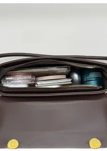 Vue intérieure du sac en cuir marron montrant l'espace pour téléphone et maquillage