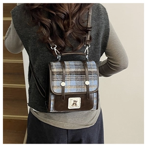 Detail of the plaid patchwork design and cute bear patch on this British school-style backpack