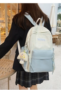 Close-up of star print backpack detail featuring plush mushroom pendant and side pockets