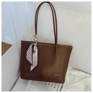Détail du sac cabas marron avec foulard élégant et texture en cuir synthétique haut de gamme