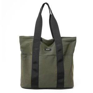 Close-up of olive green nylon tote bag with black canvas handles and logo detail