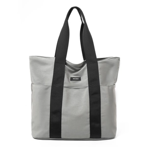 Detail of grey tote bag featuring durable nylon fabric and black webbed shoulder straps