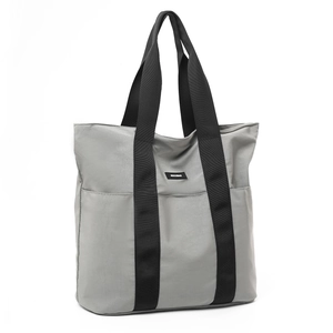 Detail of grey waterproof nylon tote bag with reinforced black straps and MOCOBAG logo
