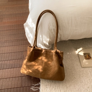 Close-up of vintage brown matte suede shoulder bag with decorative white topstitching