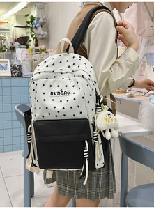 Close-up of the black star pattern and plush cloud pendant on the stylish backpack