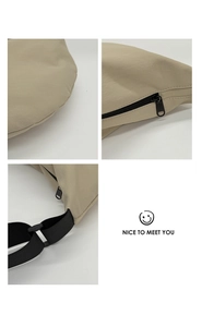 Detail view of khaki nylon fabric texture and black metal zipper on the crossbody bag
