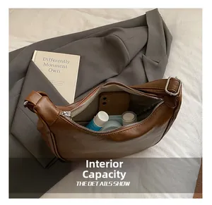 Detail view showing large interior capacity of brown lychee leather hobo bag with essentials