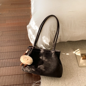 Detail of vintage matte tote bag with contrast stitching and plush sheep pendant