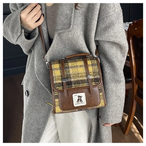 Détail du sac à bandoulière vintage en laine à carreaux avec finitions en cuir brun