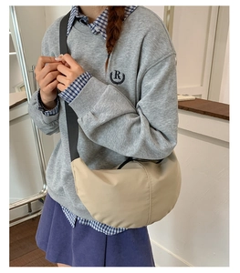 Beige nylon crescent crossbody bag with adjustable strap shown on model for daily wear