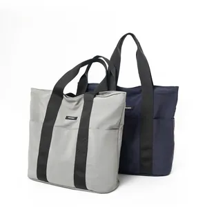 Close-up of minimalist large tote bags in grey and navy with reinforced handles