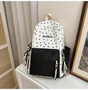 Detail of canvas backpack with star print, contrast front pocket and striped rope knots