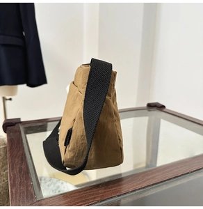 Détail du sac seau en nylon kaki avec tissu texturé et large bandoulière noire
