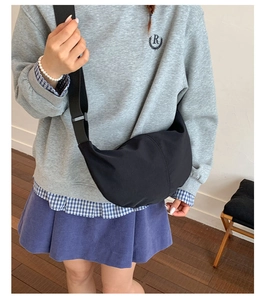 Detailed top view of the black crescent crossbody bag worn by a model for commuting