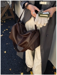 Detailansicht der braunen Leder-Tragetasche mit geräumigem Design und breitem Trageriemen