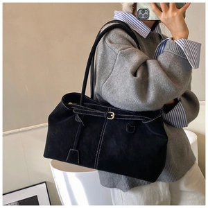 Détail du sac fourre-tout noir en suède avec surpiqûres et boucle de sangle décorative