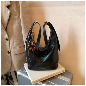 Detail der schwarzen Hobo-Tasche mit Vintage-Holzperlen-Quaste und goldener Metallschnalle