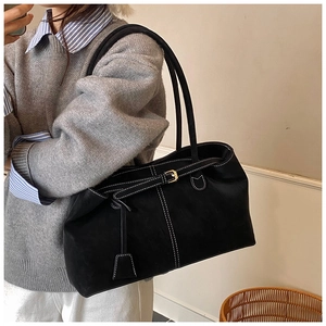 Détail du sac cabas noir avec surpiqûres blanches et boucle de sangle ajustable