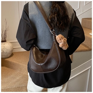 Detail view of dark brown PU leather tote with vintage pleated texture and plush charm