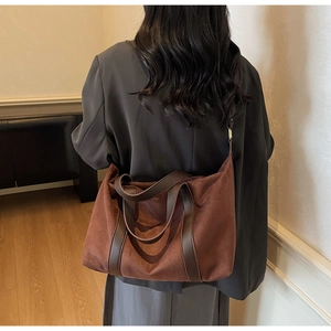 Close-up of matte suede texture and leather straps on a dark brown vintage tote bag