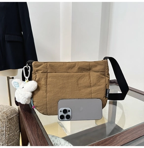 Vue détaillée d'un sac bandoulière matelassé marron avec charme de lapin en peluche