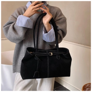 Détail du sac cabas en daim noir avec coutures contrastées blanches et boucle décorative