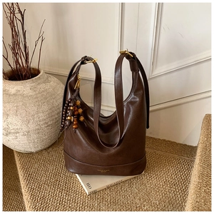 Detailaufnahme der dunkelbraunen Hobo-Tasche aus Leder mit Goldfolien-Schriftzug