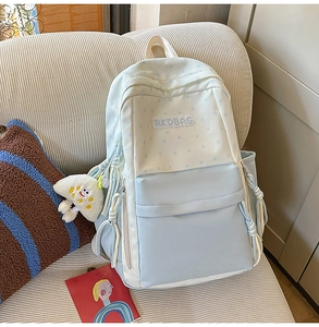 Detail of light blue contrast backpack with star patterns and a cute mushroom plush charm