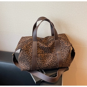 Close-up of leopard print travel tote with brown straps and large front pocket detail