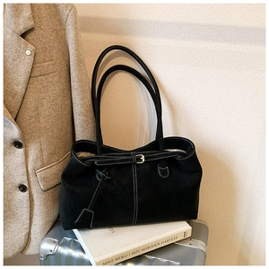Détail d'un sac cabas en cuir noir avec surpiqûres contrastées blanches et boucle déco