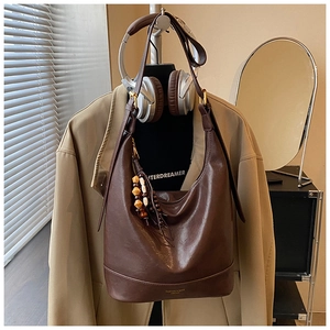 Detail der braunen Vintage-Leder-Hobotasche mit Holzperlen-Quaste und Markenlogo