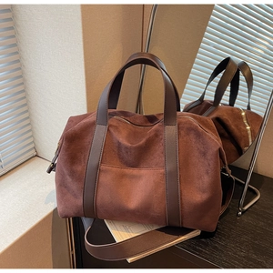 Detailed macro of a brown large capacity tote bag with suede texture and metal zipper