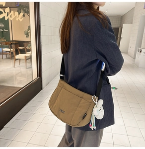 Sac seau bandoulière en nylon kaki avec pendentif lapin porté par un mannequin
