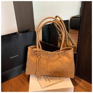 Sac fourre-tout en daim marron avec poignées nouées et étiquette, décor minimaliste