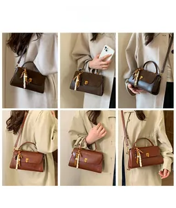 Détails du sac à bandoulière avec pompons en perles de bois et fermoir doré rotatif