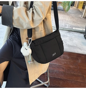 Détail du sac matelassé noir montrant la broderie Kail et le charmant petit ours blanc