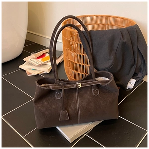 Détails du cabas en daim marron foncé avec surpiqûres blanches et boucle décorative