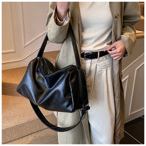Detailansicht der schwarzen Leder-Tasche mit breitem Gurt und silbernem Reißverschluss
