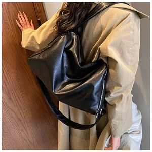 Minimalistische schwarze Schultertasche getragen zum klassischen beigen Trenchcoat