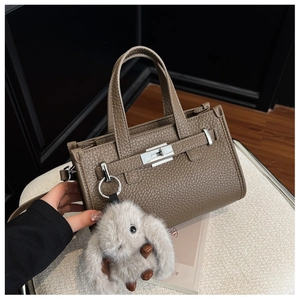 Detail of brown pebbled leather tote bag with silver hardware and cute rabbit charm