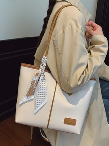 Sac fourre-tout crème tendance avec bordure marron et foulard fleuri porté par un modèle