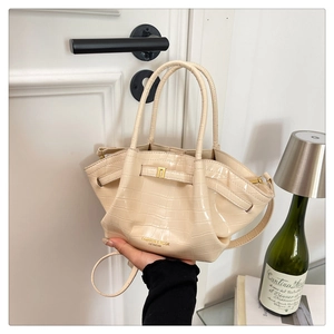 Dettaglio della borsa a secchiello in pelle coccodrillo bianco crema con logo oro