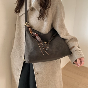 Nahaufnahme der braunen Vintage-Tasche mit Wildleder-Textur und Quasten-Anhänger-Detail