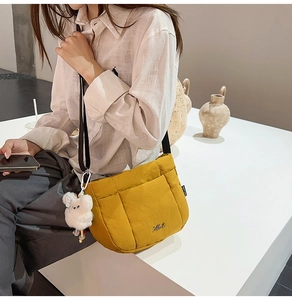 Détail du sac seau matelassé jaune gingembre avec bandoulière réglable et breloque ourson