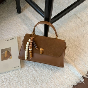 Vue détaillée du sac bandoulière marron vintage avec patchwork en daim et perles