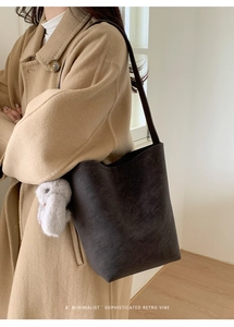 Sophisticated retro bucket bag in deep coffee brown with plush rabbit charm detail